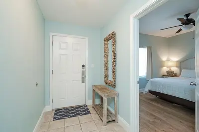 a bedroom with a bed and a table and a mirror at Laketown Wharf #119 by Nautical Properties in Panama City Beach