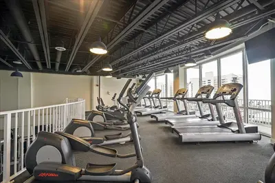 a row of treadmills in a gym with windows at Laketown Wharf #119 by Nautical Properties in Panama City Beach