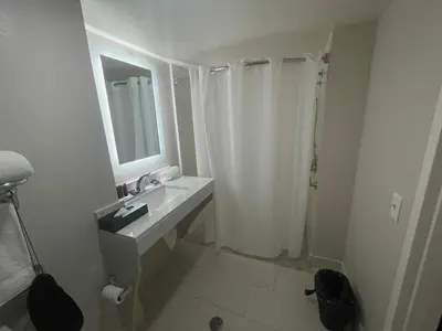 a bathroom with a sink and a shower with a mirror at Wingate by Wyndham Panama City Area Lynn Haven in Panama City