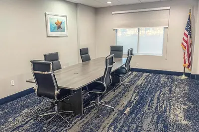 a conference room with a wooden table and chairs at Wingate by Wyndham Panama City Area Lynn Haven in Panama City