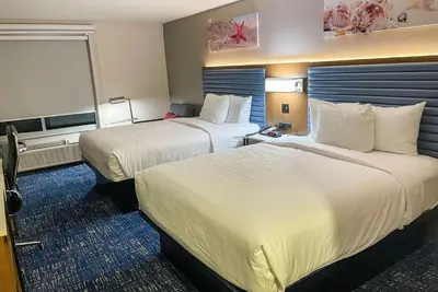 a hotel room with two beds with white sheets at Wingate by Wyndham Panama City Area Lynn Haven in Panama City