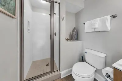 a white bathroom with a shower and a toilet at Aqua Resort 401 - Piece of Serenity in Panama City Beach