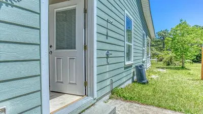 a blue house with a door and a trash can at Flip Flop Cottage - Great rates and dog friendly with additional pet fee in Santa Rosa Beach