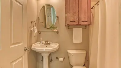 a bathroom with a sink and a toilet and a mirror at Flip Flop Cottage - Great rates and dog friendly with additional pet fee in Santa Rosa Beach