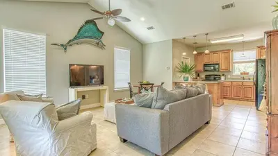a living room with two couches and a kitchen at Flip Flop Cottage - Great rates and dog friendly with additional pet fee in Santa Rosa Beach