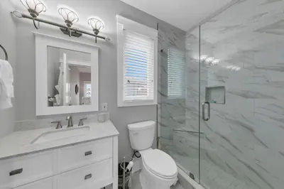 a bathroom with a toilet and a glass shower at Seashine and Sunkises - Great pricing near Seaside in Santa Rosa Beach
