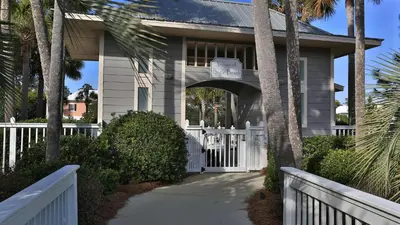 a house with a white fence and palm trees at Seashine and Sunkises - Great pricing near Seaside in Santa Rosa Beach