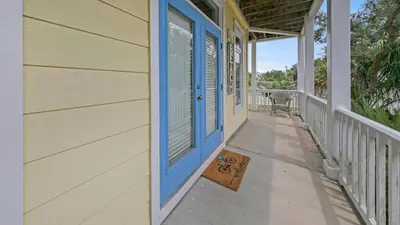 a house with a blue door on a porch at Seashine and Sunkises - Great pricing near Seaside in Santa Rosa Beach
