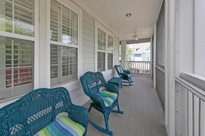a porch with three blue chairs and windows at Memory Maker II - Modern Home with 4Bedrooms and 3 and a half baths in Seagrove Beach along 30a in Santa Rosa Beach