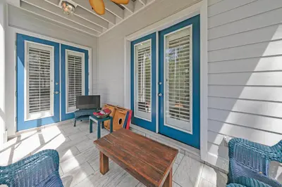 a porch with blue doors and a wooden table at Memory Maker II - Modern Home with 4Bedrooms and 3 and a half baths in Seagrove Beach along 30a in Santa Rosa Beach