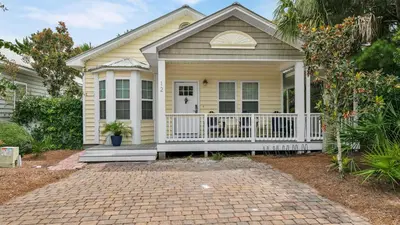 a small yellow house with a white porch at Luna Sea - Is a short walk to the beach and close to Seaside in Santa Rosa Beach