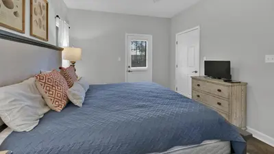 a bedroom with a blue bed with a television on a dresser at Luna Sea - Is a short walk to the beach and close to Seaside in Santa Rosa Beach