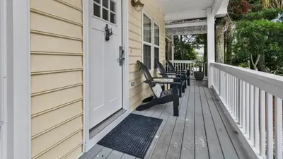 a porch with two benches on a house at Luna Sea - Is a short walk to the beach and close to Seaside in Santa Rosa Beach