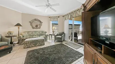 a living room with a couch and a tv at Dunes of Seagrove 301B - Updated decor with Great views and Beach service included March through October in Santa Rosa Beach