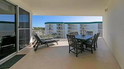 a patio with a table and chairs on a balcony at Dunes of Seagrove 301B - Updated decor with Great views and Beach service included March through October in Santa Rosa Beach