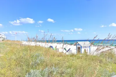 a beach with a fence and the ocean in the background at Dunes of Seagrove 301B - Updated decor with Great views and Beach service included March through October in Santa Rosa Beach