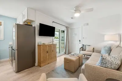 a living room with a couch and a tv at Beachside Villas #312 in Santa Rosa Beach