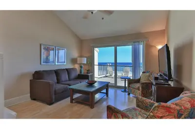 a living room with a couch and a tv and a table at Commodore's Retreat 402 - Beach service included 2 chairs and 1 umbrella March through October in Santa Rosa Beach