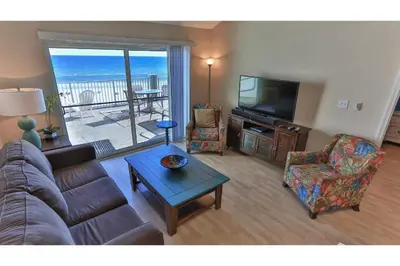 a living room with a couch and a flat screen tv at Commodore's Retreat 402 - Beach service included 2 chairs and 1 umbrella March through October in Santa Rosa Beach
