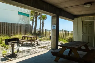 a patio with a picnic table and a grill at Commodore's Retreat 402 - Beach service included 2 chairs and 1 umbrella March through October in Santa Rosa Beach