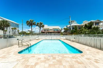 a swimming pool in a yard with a fence at Commodore's Retreat 402 - Beach service included 2 chairs and 1 umbrella March through October in Santa Rosa Beach