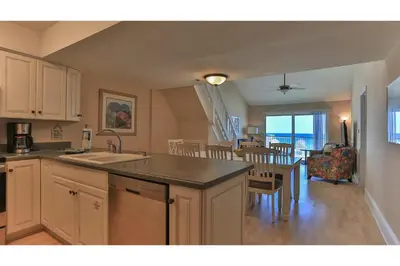 a kitchen and dining room with a view of the ocean at Commodore's Retreat 402 - Beach service included 2 chairs and 1 umbrella March through October in Santa Rosa Beach
