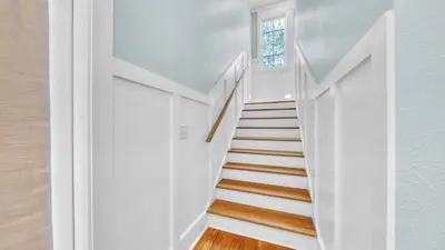 a staircase with white walls and a window at Top of the Dunes - Recently Redecorated Short walk to the Beach in Santa Rosa Beach