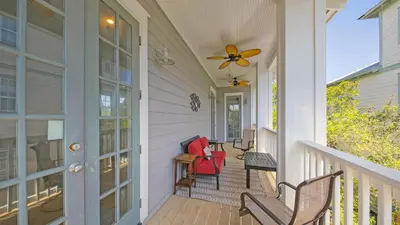 a porch with rocking chairs and a ceiling fan at Top of the Dunes - Recently Redecorated Short walk to the Beach in Santa Rosa Beach