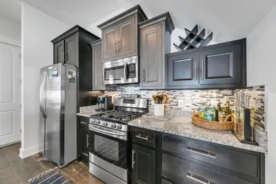 a kitchen with black cabinets and a stainless steel refrigerator at Seagrove Serenity - Seagrove Beach 30a 3BD 3BA Home in Santa Rosa Beach