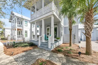 a white house with a porch and a palm tree at Seagrove Serenity - Seagrove Beach 30a 3BD 3BA Home in Santa Rosa Beach
