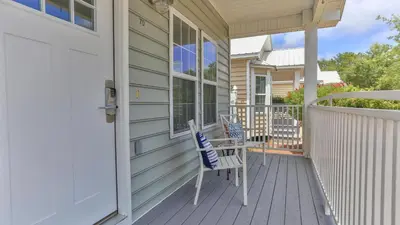 a porch with two chairs on a house at Elsie's Cove - Close to the Beach in Seagrove along 30A in Santa Rosa Beach