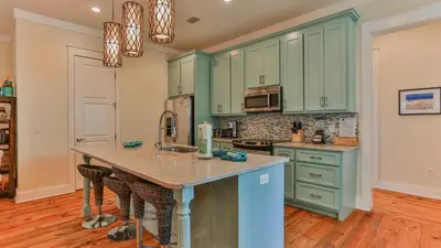 a kitchen with green cabinets and a counter top at Family Ties - Located in Seacrest Beach 2 Master bedrooms and a large communal pool in Rosemary Beach