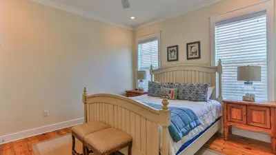a bedroom with a bed and a chair and a window at Family Ties - Located in Seacrest Beach 2 Master bedrooms and a large communal pool in Rosemary Beach