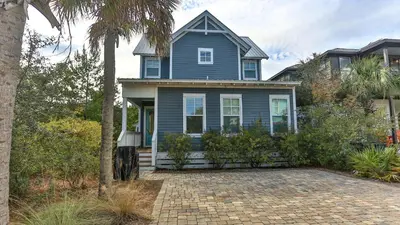 a blue house with a palm tree in front of it at Family Ties - Located in Seacrest Beach 2 Master bedrooms and a large communal pool in Rosemary Beach