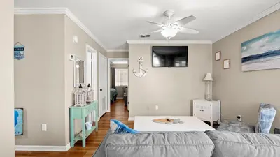 a living room with a couch and a ceiling fan at Great Vibes in Panama City Beach