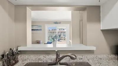 a kitchen with a sink and a mirror over a counter at Great Vibes in Panama City Beach