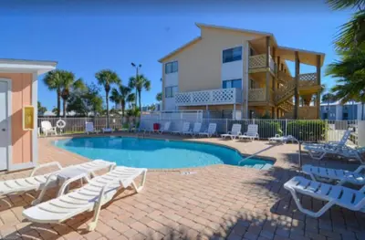 a swimming pool with lounge chairs and a house at Great Vibes in Panama City Beach