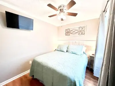 a bedroom with a bed and a ceiling fan at Great Vibes in Panama City Beach