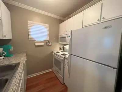a kitchen with a refrigerator and a stove and a window at Great Vibes in Panama City Beach