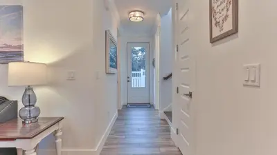 a hallway with a table and a lamp and a door at Hook, Wine, and Sinker - 3 plus Bedrooms Gulf views on 30A sleeps 12 with a hot tub in Santa Rosa Beach