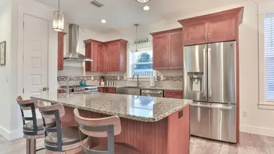 a kitchen with wooden cabinets and stainless steel appliances at Hook, Wine, and Sinker - 3 plus Bedrooms Gulf views on 30A sleeps 12 with a hot tub in Santa Rosa Beach