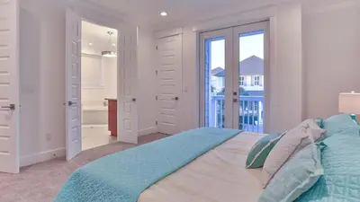 a white bedroom with a bed and a balcony at Hook, Wine, and Sinker - 3 plus Bedrooms Gulf views on 30A sleeps 12 with a hot tub in Santa Rosa Beach