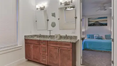 a bathroom with a sink and a bedroom with a bed at Hook, Wine, and Sinker - 3 plus Bedrooms Gulf views on 30A sleeps 12 with a hot tub in Santa Rosa Beach