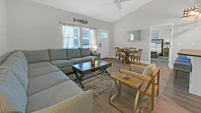 a living room with a couch and a table at Once Upon a Tide - Close to Seaside on 30A and 3 blocks to beach in Santa Rosa Beach
