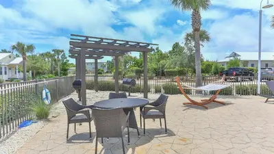 a patio with a table and chairs and a pergola at Once Upon a Tide - Close to Seaside on 30A and 3 blocks to beach in Santa Rosa Beach