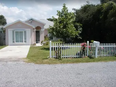 a white picket fence in front of a house at Dolphin house with Private Pool and Near Beach in Panama City Beach