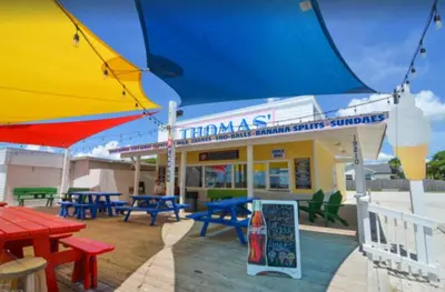 a restaurant with tables and umbrellas in front of it at Dolphin house with Private Pool and Near Beach in Panama City Beach
