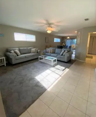 a living room with two couches and a table at Dolphin house with Private Pool and Near Beach in Panama City Beach