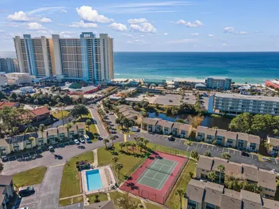 an aerial view of a city with a tennis court and the ocean at Gulf Highlands #106 in Panama City Beach