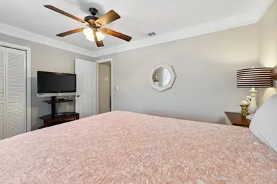 a bedroom with a bed and a ceiling fan at Gulf Highlands #106 in Panama City Beach